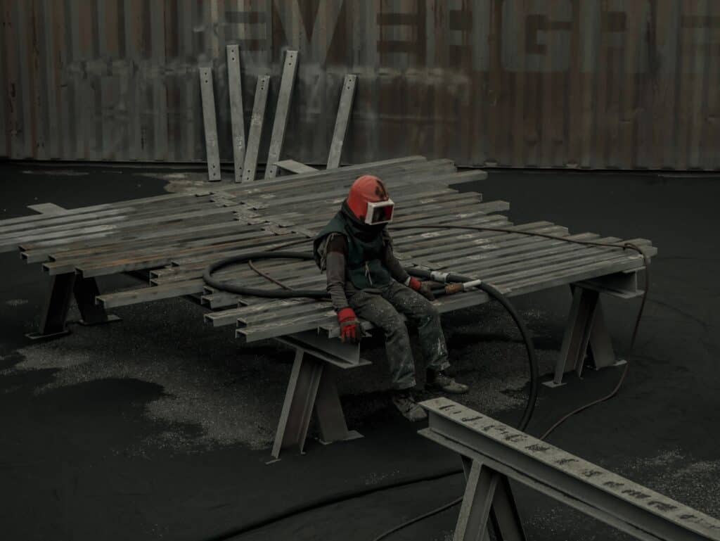 Worker sitting with blasting equipment